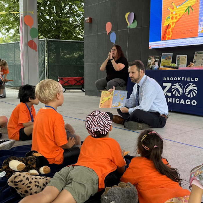 Dr. Mike Adkesson reads a book to children at the zoo. 