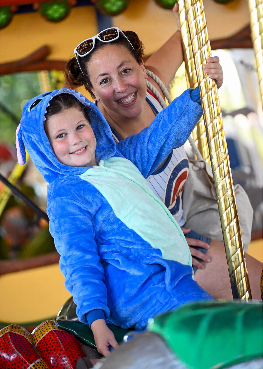 A child dressed in a costume rides the carousel. 