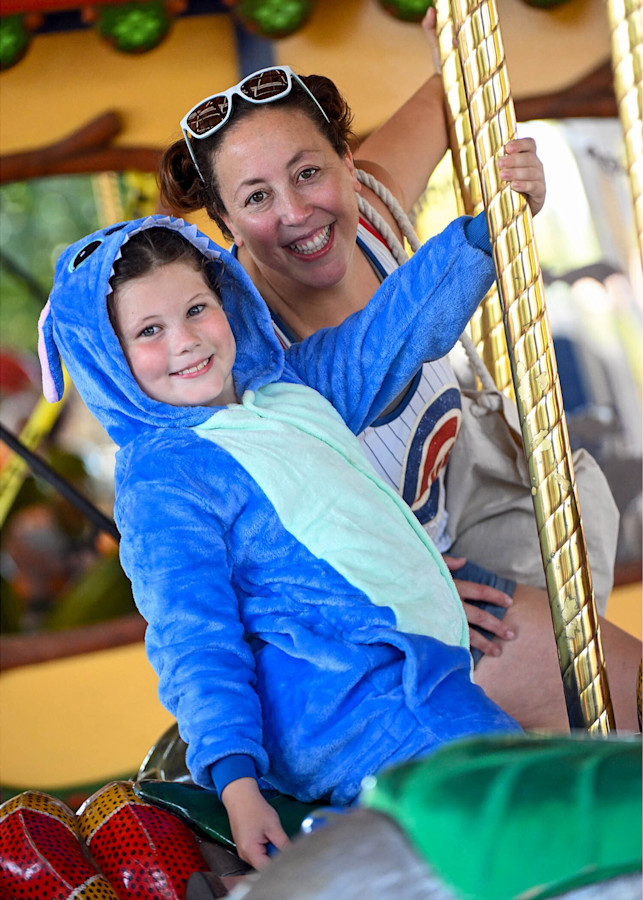 A child dressed in a costume rides the carousel.
