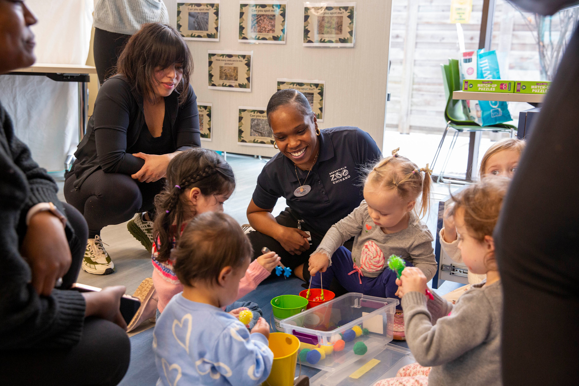 An educator helps young kids with an activity