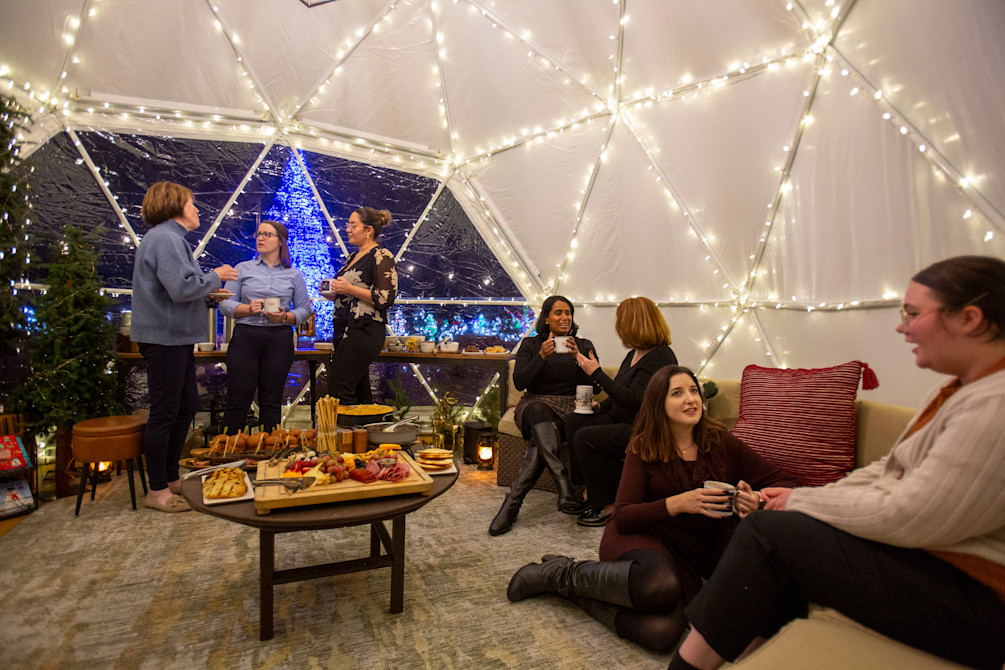 The inside of the holiday igloo, full of twinkle lights and guests. 