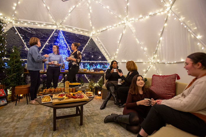 The inside of the holiday igloo, full of twinkle lights and guests.