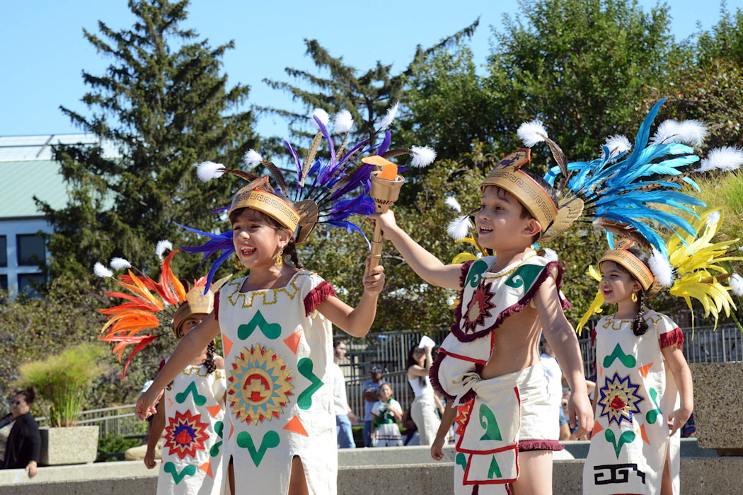 Children dressed in cultural-significant clothing stand in a group. 