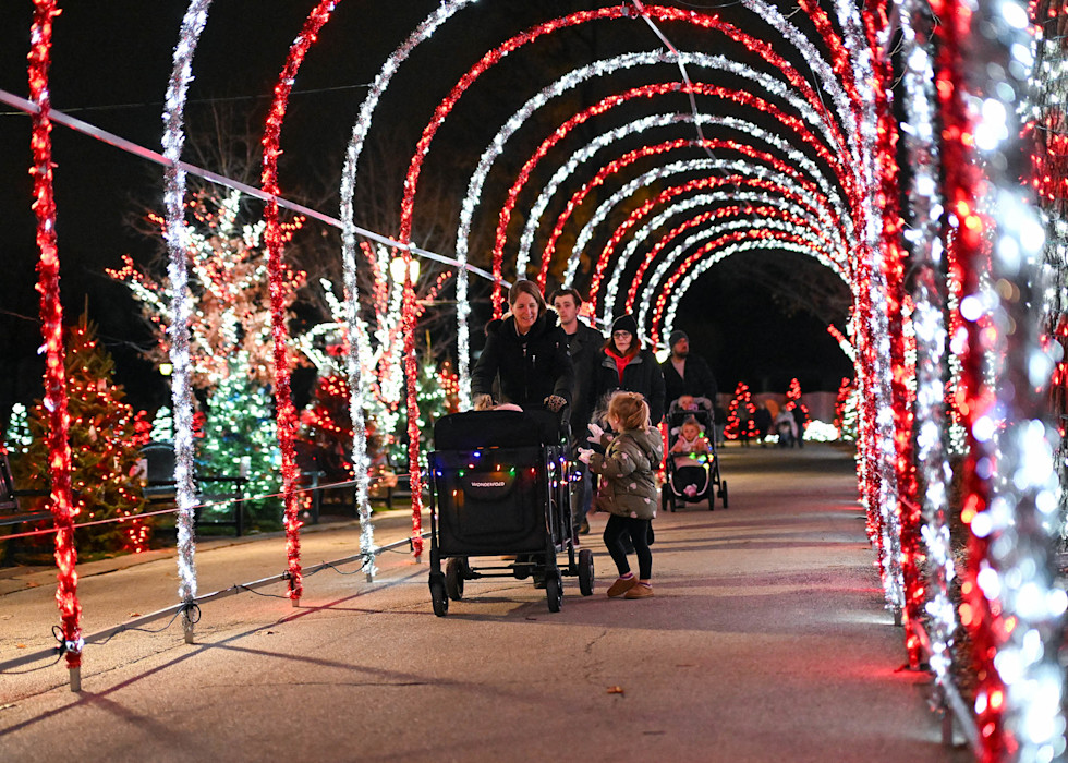 A family walks through a red and white striped tunnel.