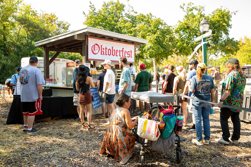 Folks stand to wait for a drink at the Oktoberfest beer stand. 