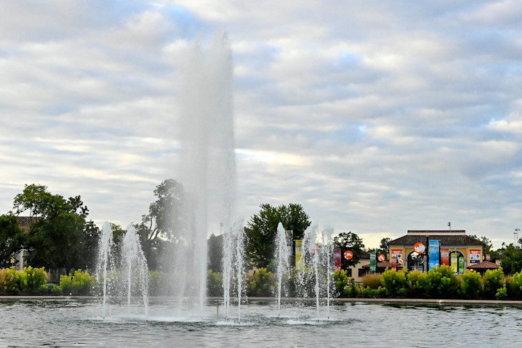 The Roosevelt Fountain sprays water, the South Gate featured behind it. 