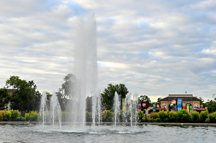 The Roosevelt Fountain sprays water, the South Gate featured behind it. 