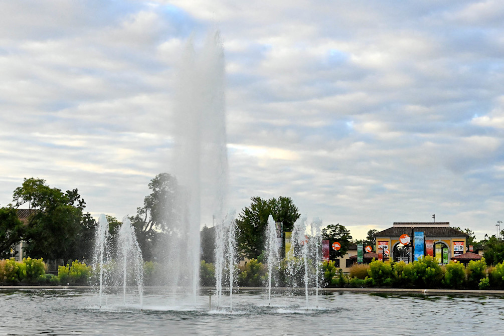The Roosevelt Fountain sprays water, the South Gate featured behind it.