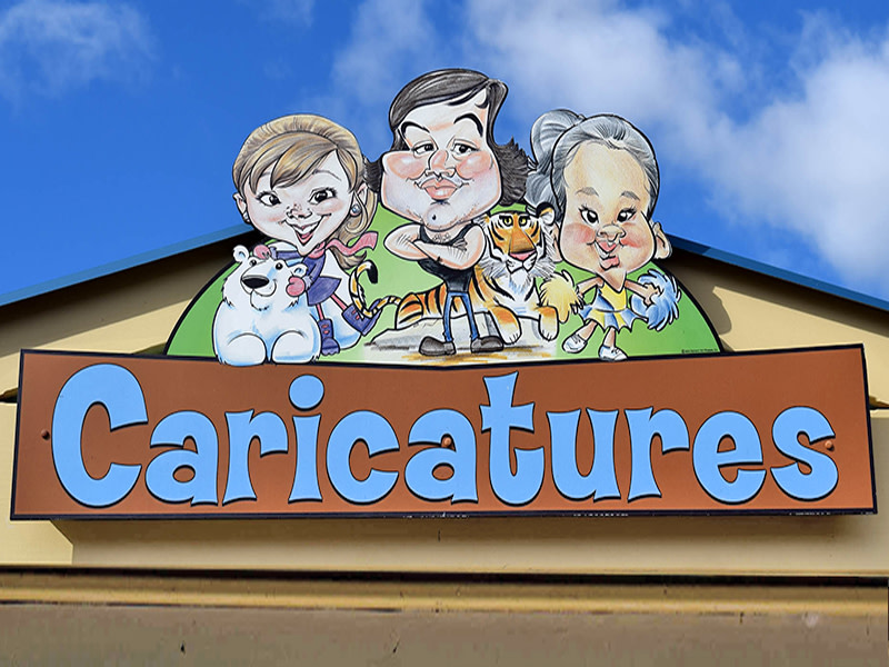 A sign outside of the caricature artist stand at Brookfield Zoo Chicago, featuring three caricature portraits. 