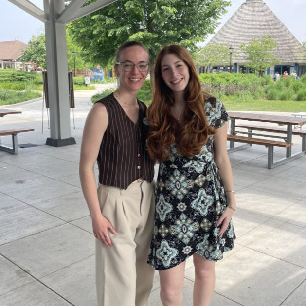 Two members of the alumni network stand next to each other. 