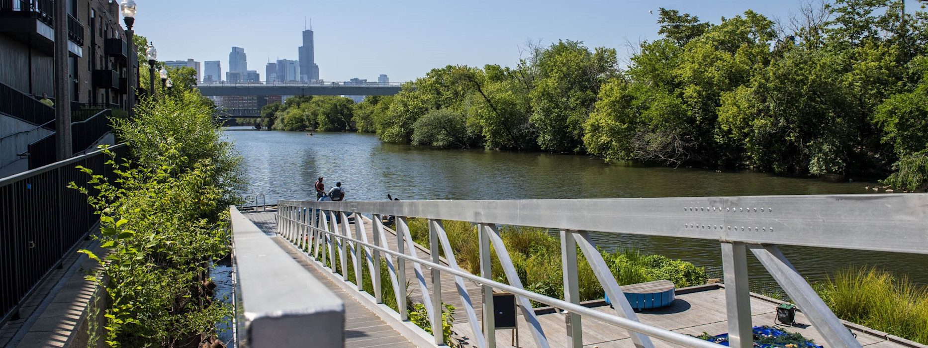 A photograph of a pier on the Chicago River with a view to the Chicago skyline.