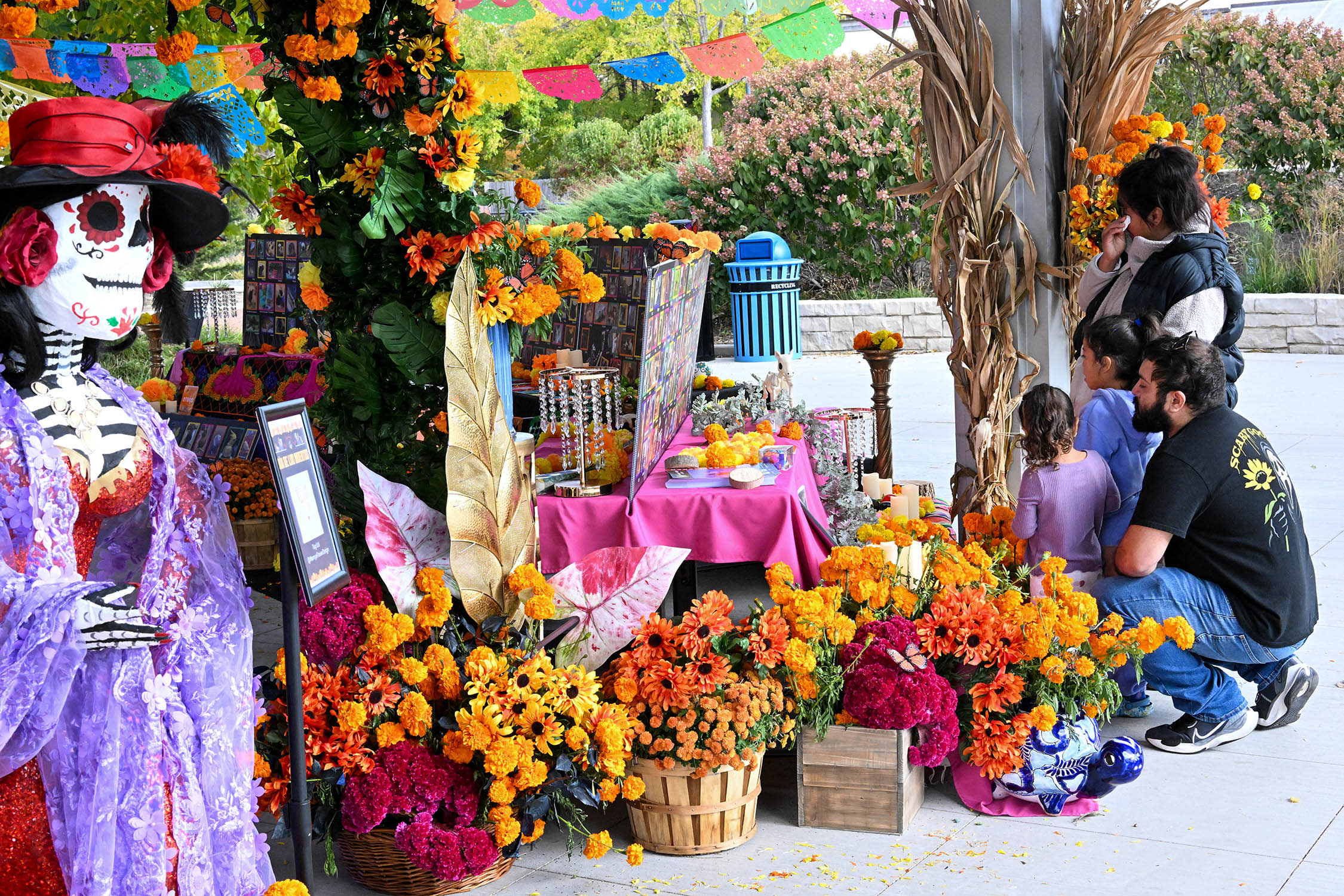 Brightly colored flowers surround an ofrenda featuring beloved pets.